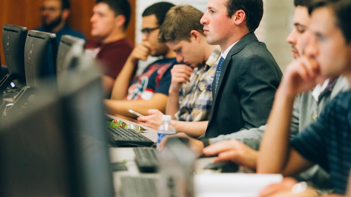 Students sit in a row in one of the Trinity computer labs