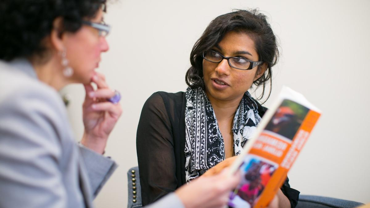 student and her professor discuss a book